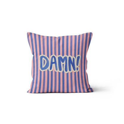 Coussin rayé bleu et rose avec l'inscription typographique DAMN! au centre